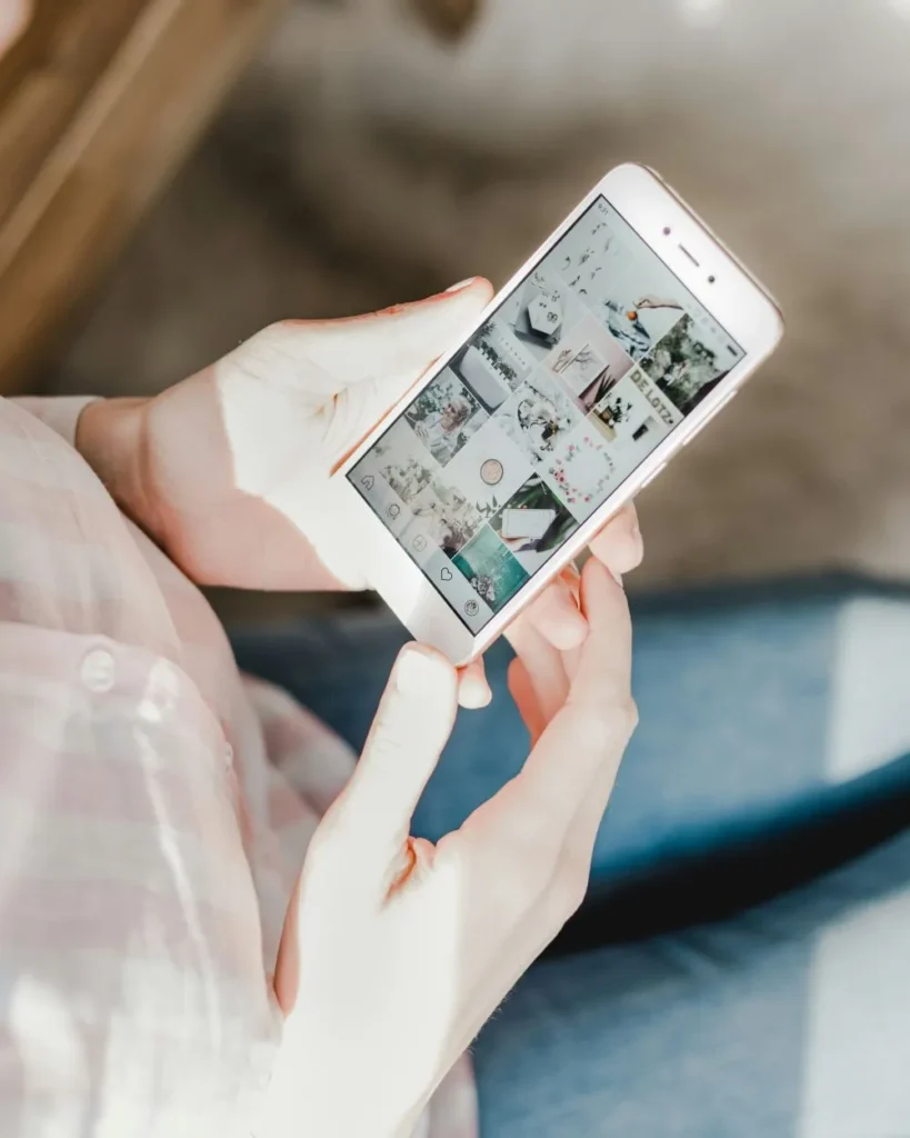 Utilizador a navegar no feed do Instagram através do smartphone, explorando conteúdos visuais e publicações